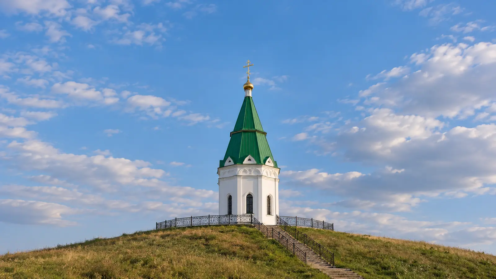 Белая часовня с зелёной кровлей на холме